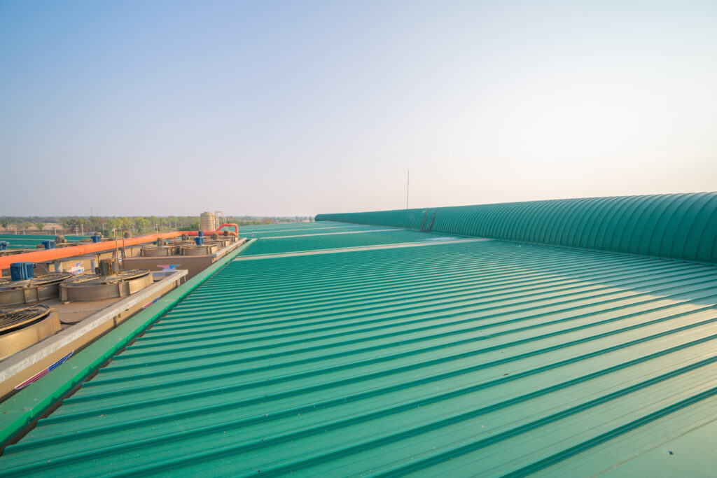 Metal sheet corrugated roof on rooftop of industry factory. Steel structure of station building